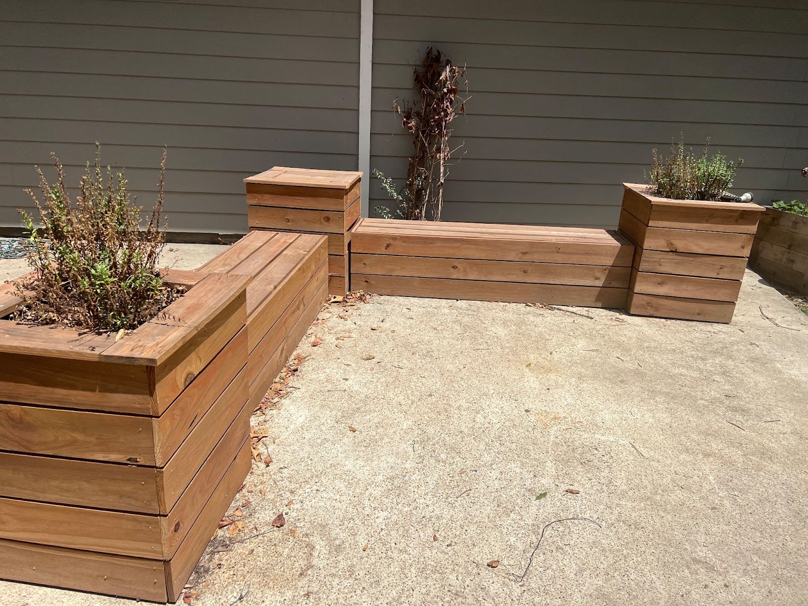 A corner bench made out of pressure treated lumber with garden boxes built in.